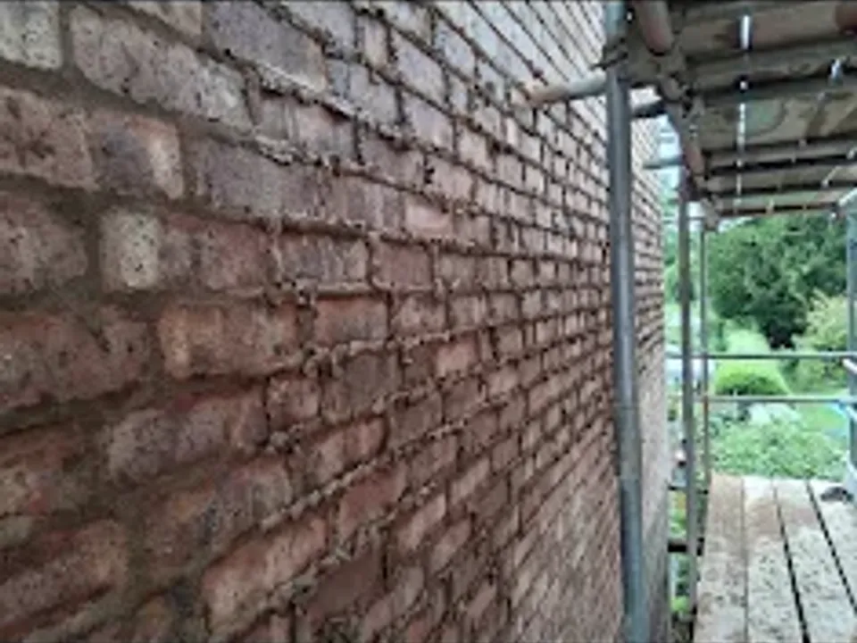 A brick wall with scaffolding up for repointing work