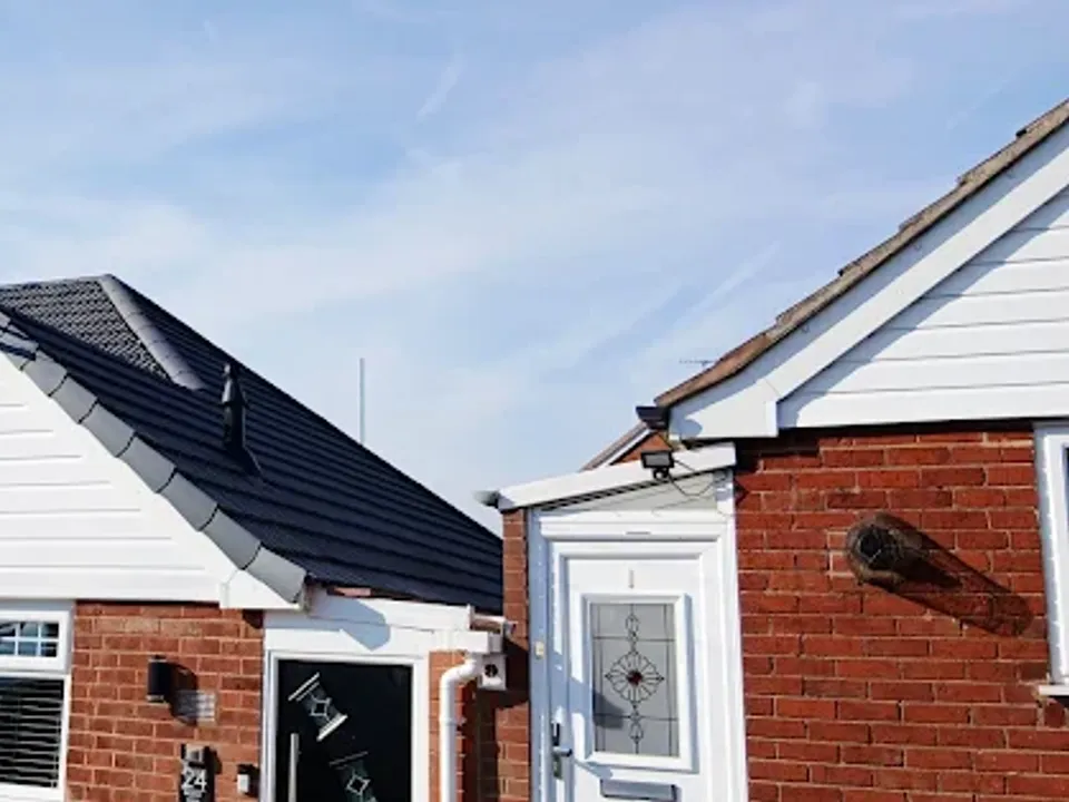 Finished dark roof on a white rendered house with a bay window