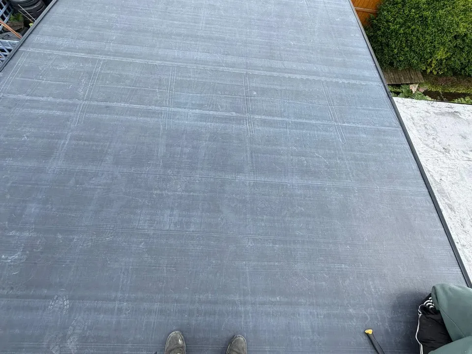 A smooth, newly finished grey flat roof by JWJ Brickwork & Roofing