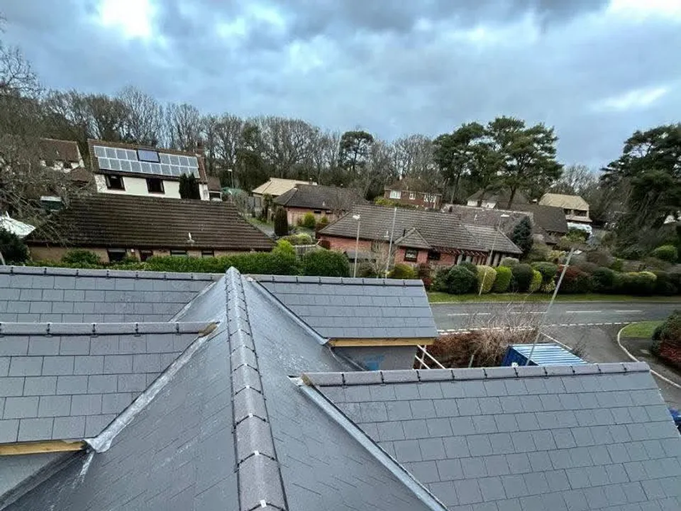 New grey slate roof ridge overlooking a village