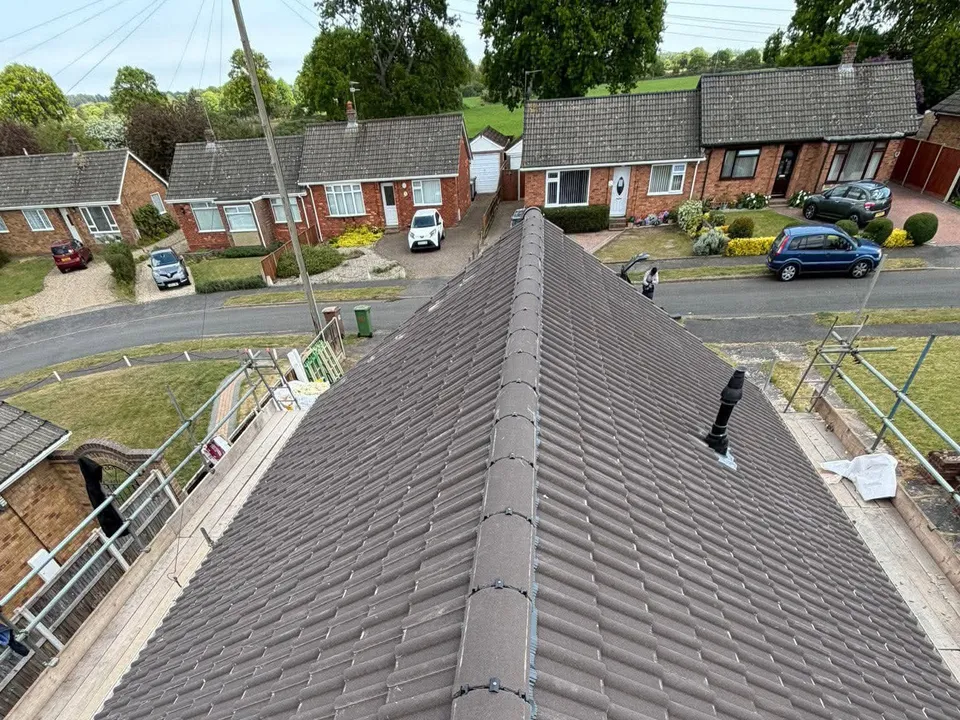 Grey tiled hipped roof seen from above with a street beyond