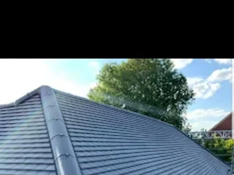 Close-up of a new grey tiled roof and ridge line