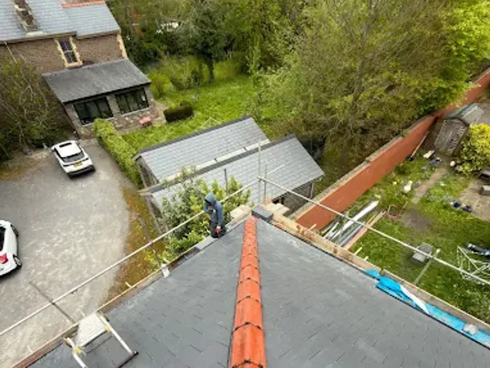 Red ridge tiles running down a newly finished roof above a driveway
