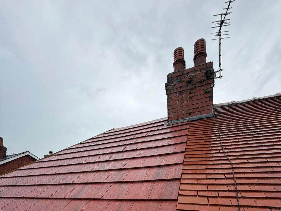 Completed red tiled roof with a repointed chimney