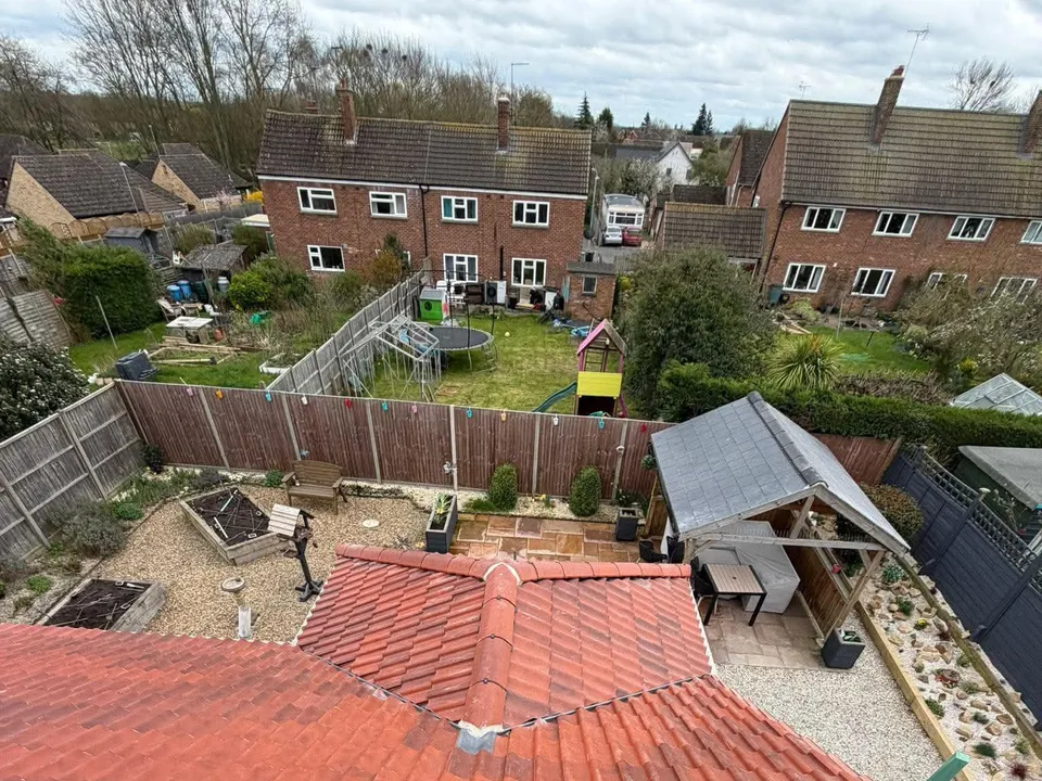 Red tiled roof valley on a completed re-roof with rooftops beyond